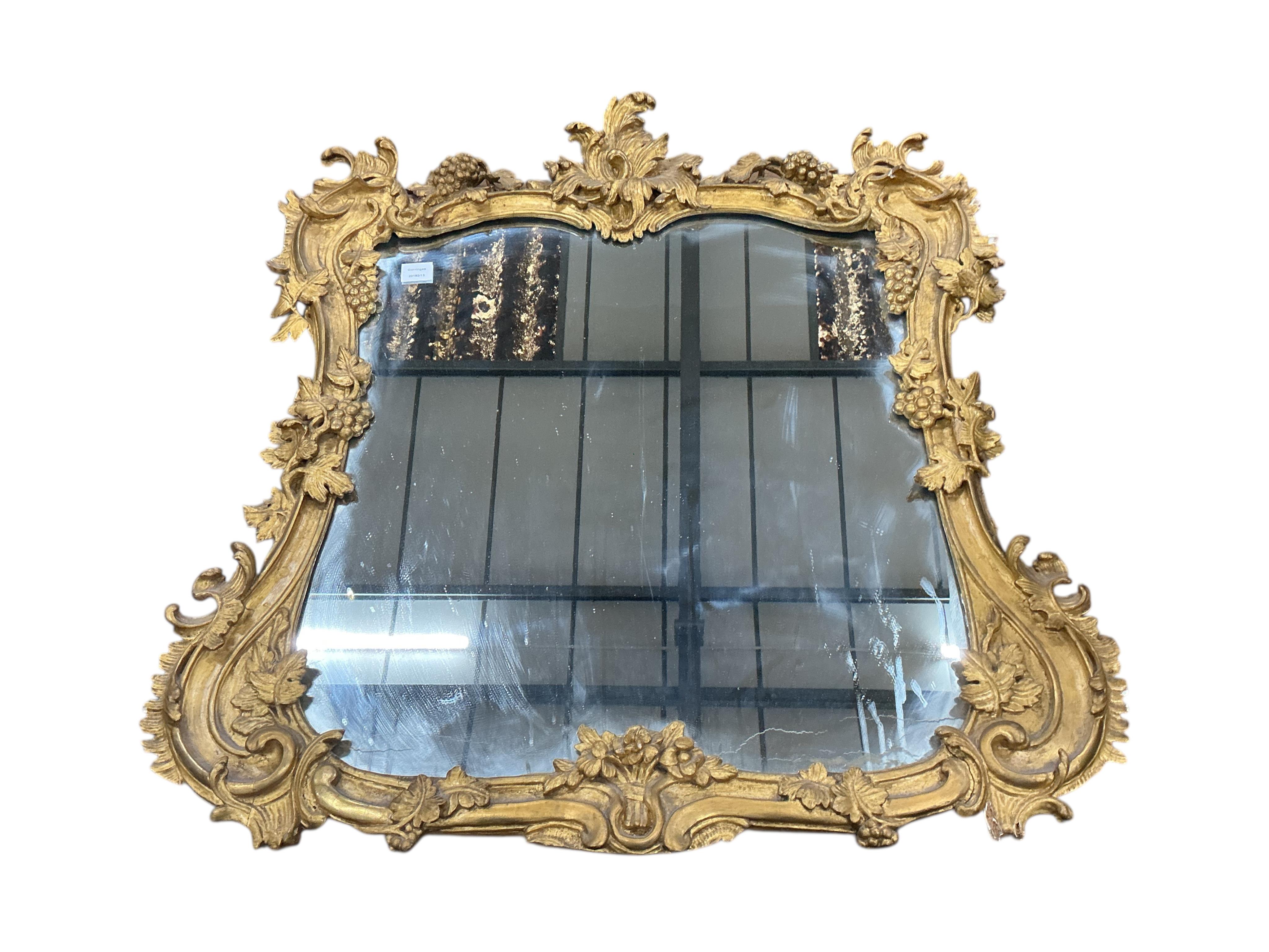 A Victorian carved giltwood and composition wall mirror with fruiting vine borders, width 98cm, height 104cm